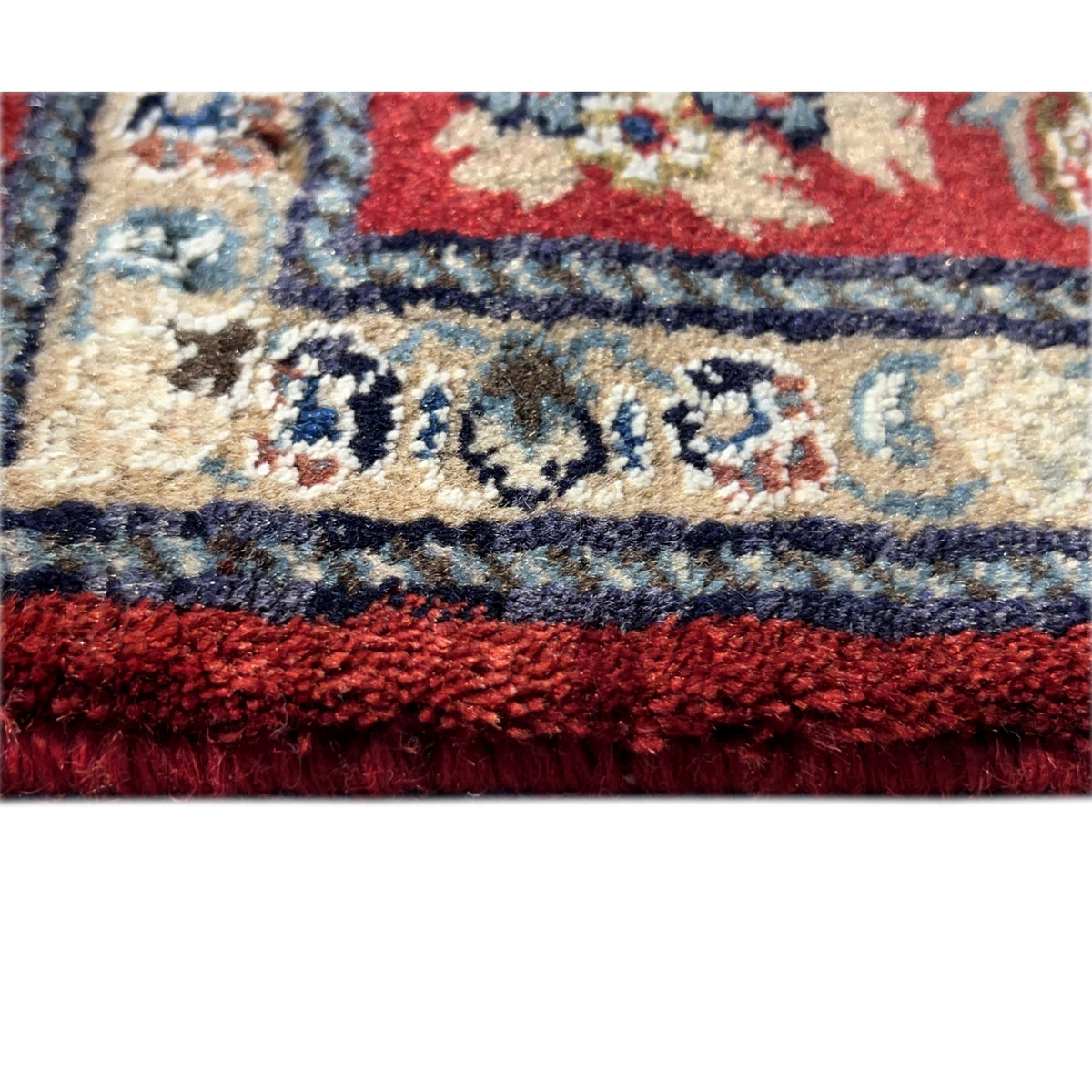 Close-up of the carpet pile with a red and beige ornamental pattern