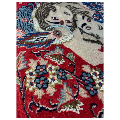 Close-up of the design on a red carpet with figures and an animal depiction
