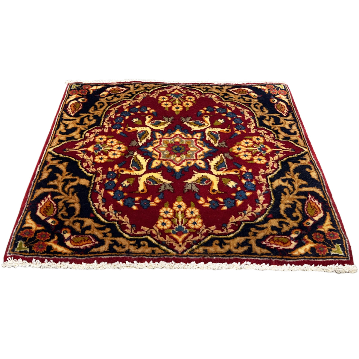 Square rug with a red border design, dark blue background, and fringes