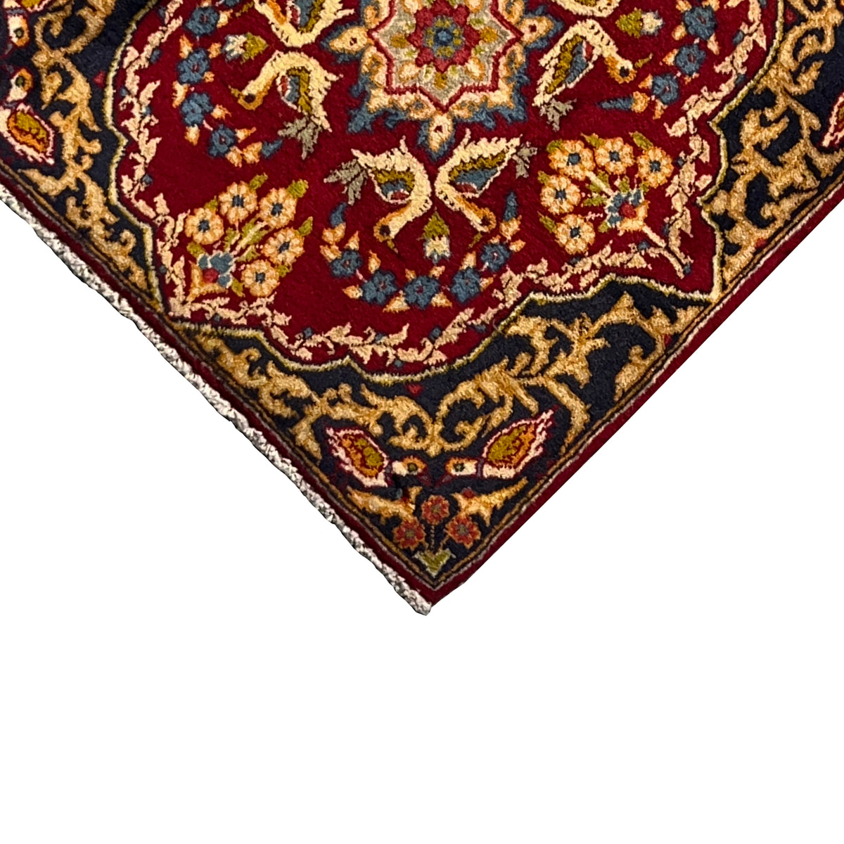 Carpet detail view: red field with blue-and-gold patterns, dark border, fringes
