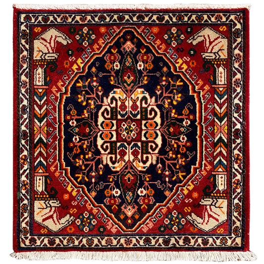 Quadratischer Teppich mit dunkelblauem Grund und rotem Rautenmuster, Fransen an den Ecken
