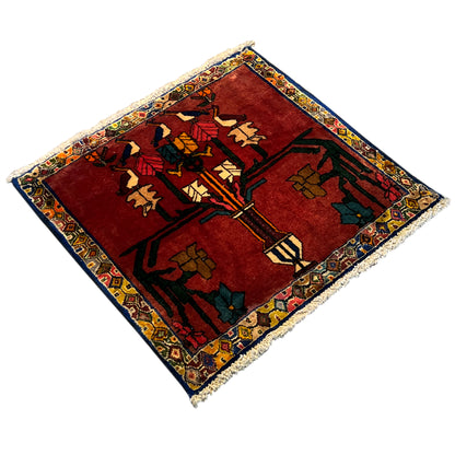 Rectangular rug with a red background and colorful oriental pattern, photographed diagonally, fringes