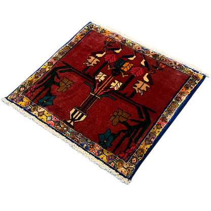 Rug with a red background and colorful ornaments, central motif and surrounding border, fringes