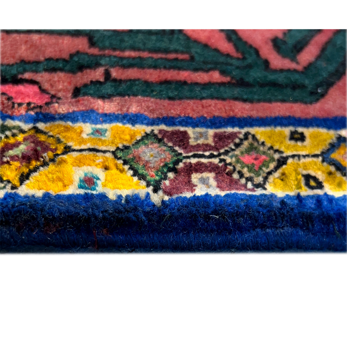Close-up of the lower edge of the carpet with a blue and yellow border and short fringes