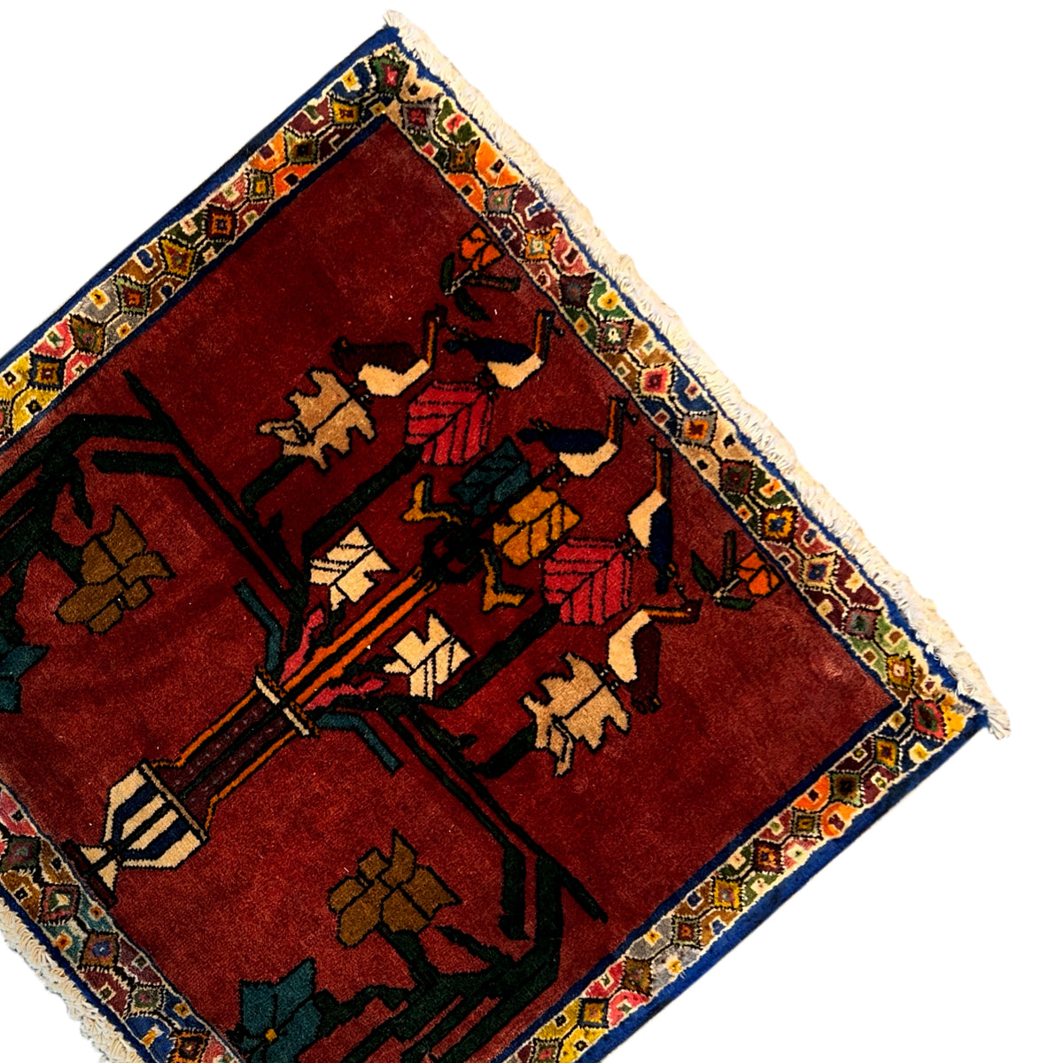 Carpet at an angle: red background, colorful oriental pattern, surrounding border, fringes