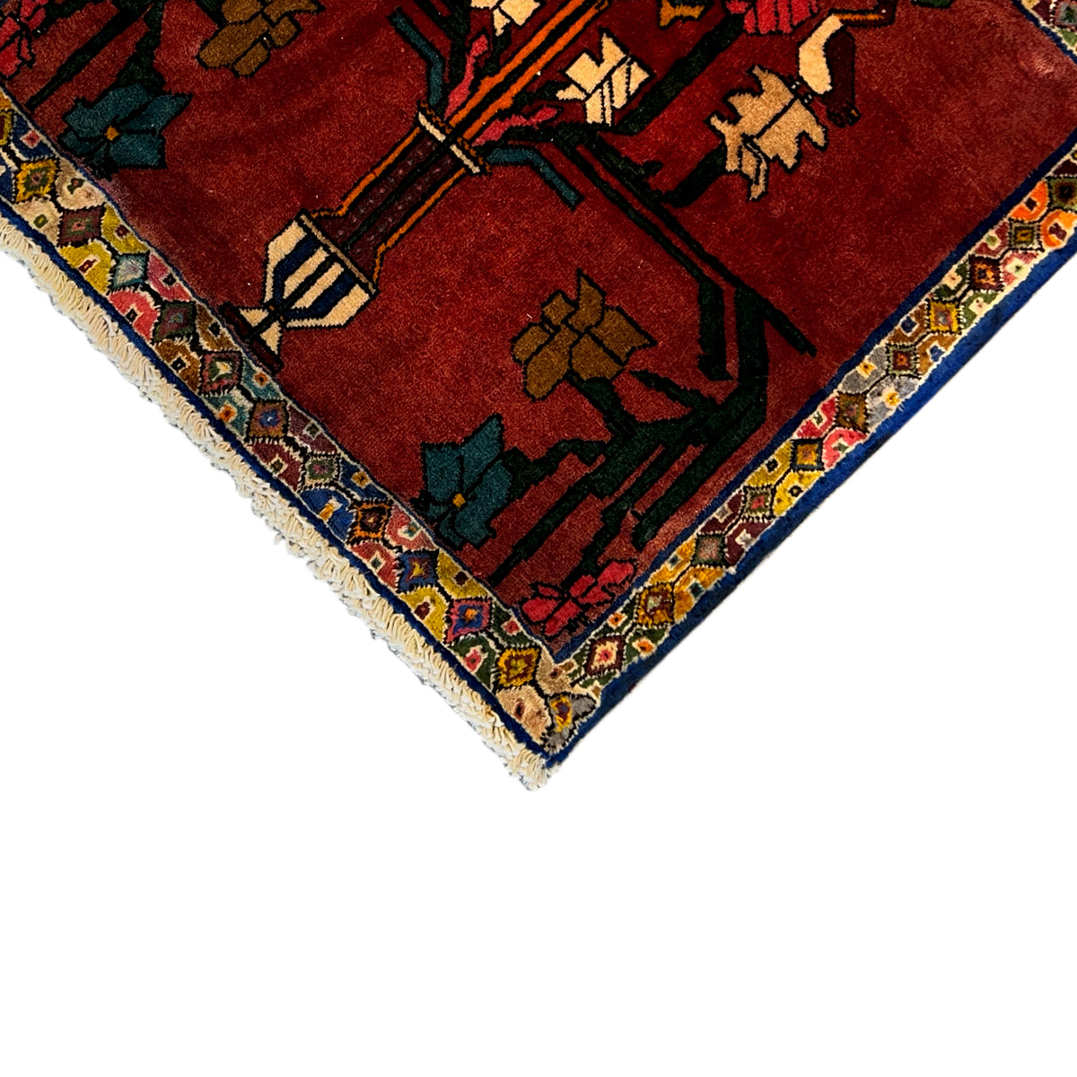 Corner view: red carpet with a multicolored medallion pattern, border, and fringe