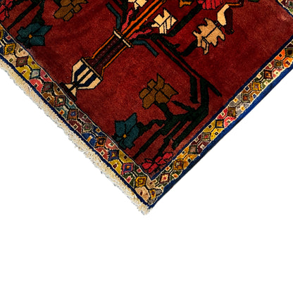 Corner view: red carpet with a multicolored medallion pattern, border, and fringe