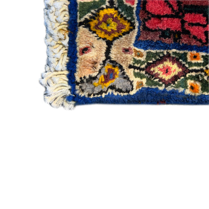 Rug corner with light-colored fringes and colorful motifs, blue-trimmed edge