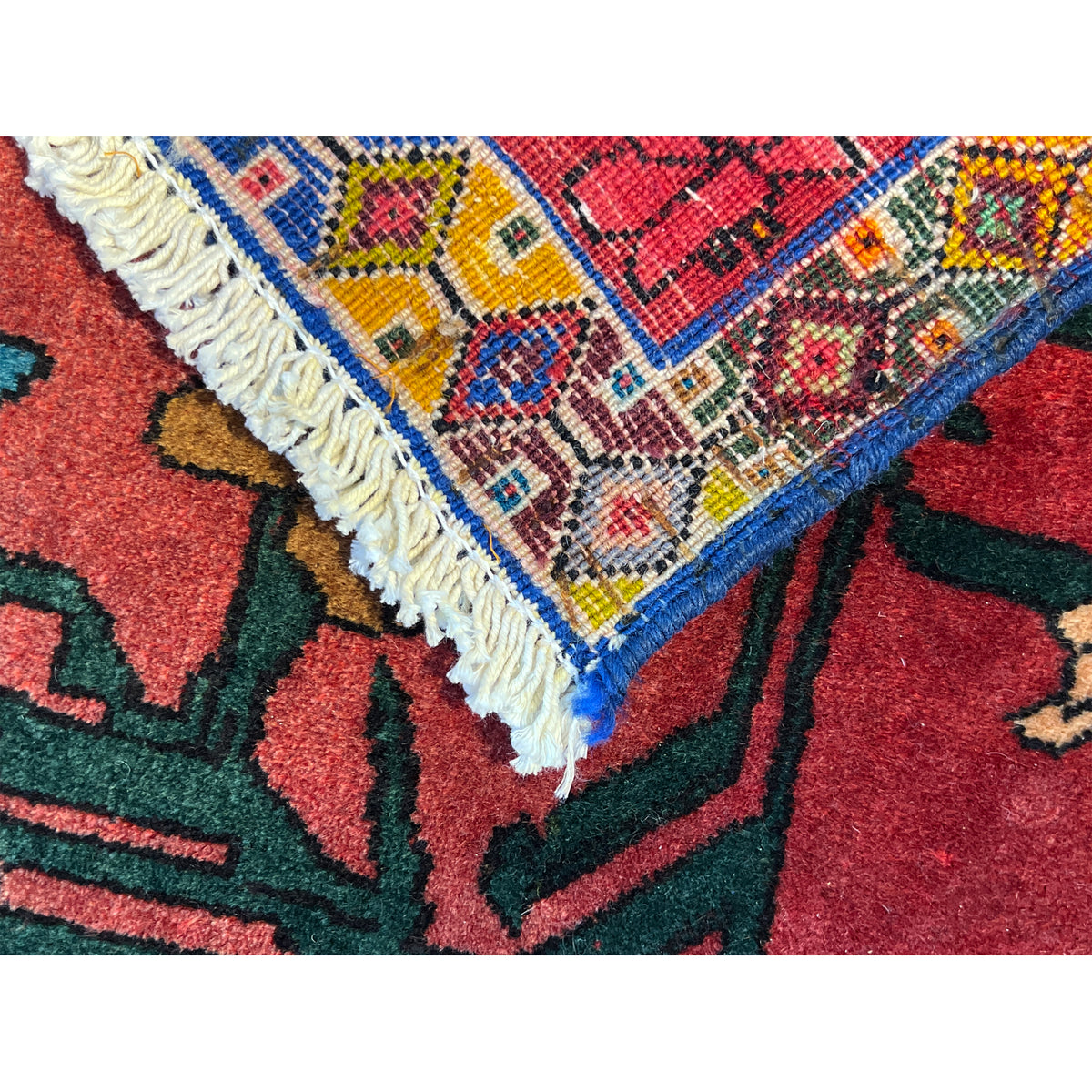 Close-up of the carpet edge: fringe trim and multicolored pattern in the border area