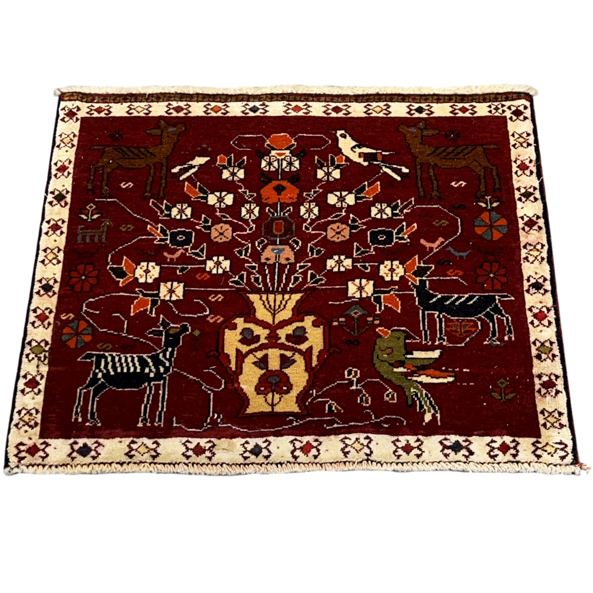 Red Poshti rug laid flat with a decorative figurative pattern and beige border