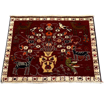 Red Poshti rug laid flat with a decorative figurative pattern and beige border