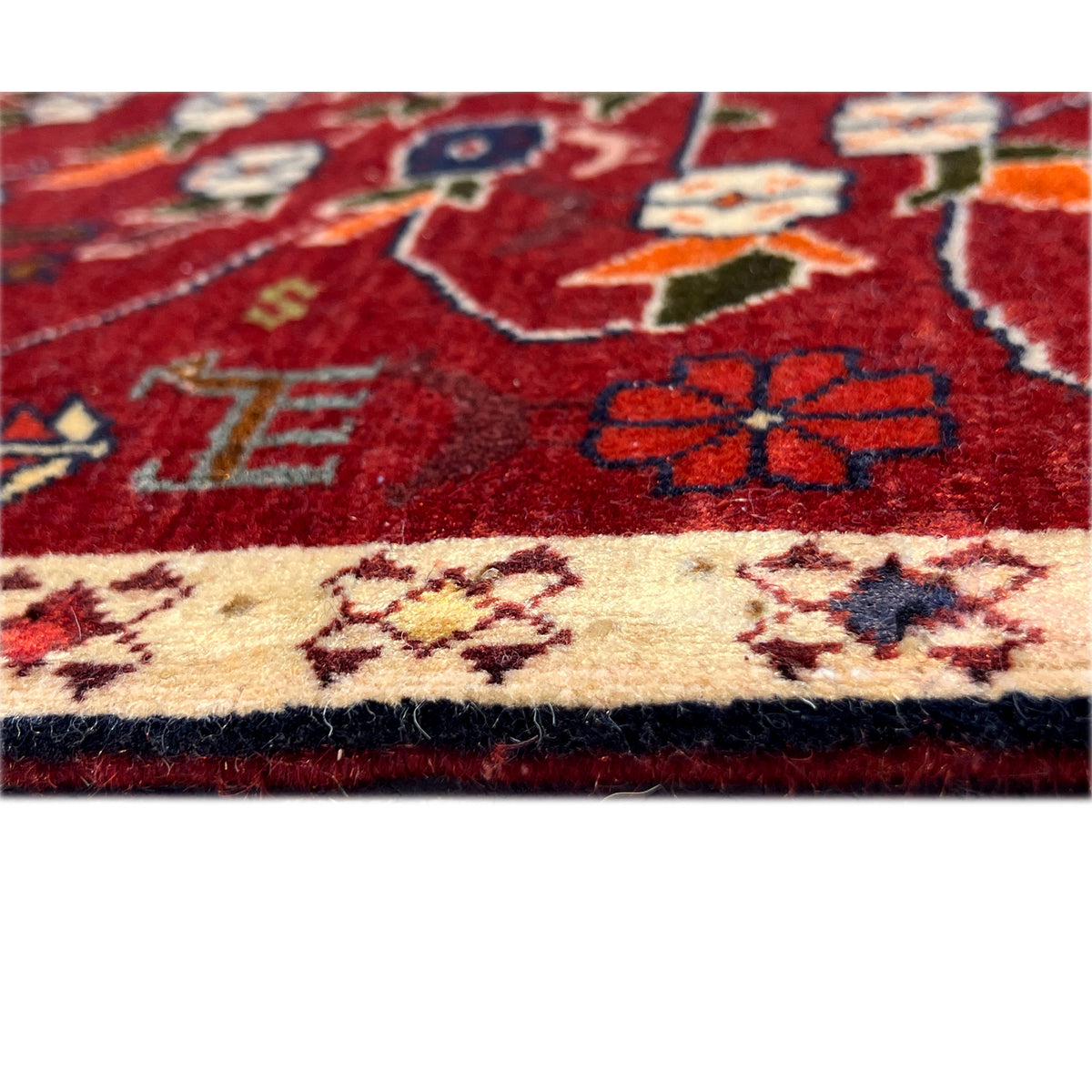 Detail from the red carpet: beige trim with patterned stripes, fine fringes