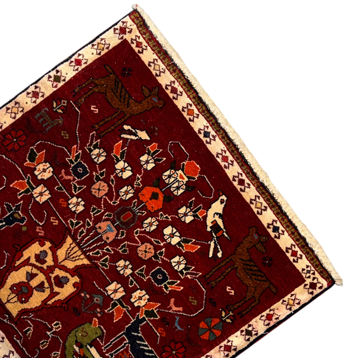 Close-up of a red Poshti rug with a central motif, colorful figures, and a beige border