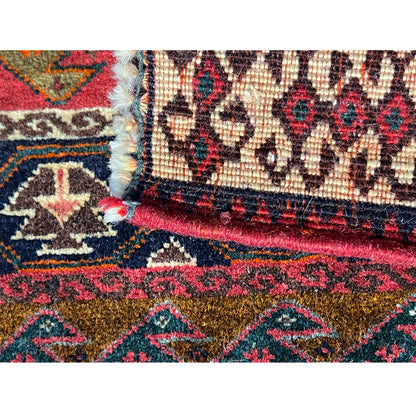 Detail of the edge of a colorful Poshti rug with fringe and decorative stitching