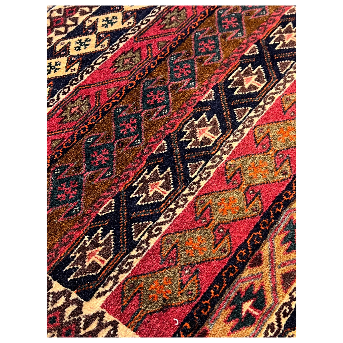 Close-up of the Poshti rug with a colorful geometric pattern field