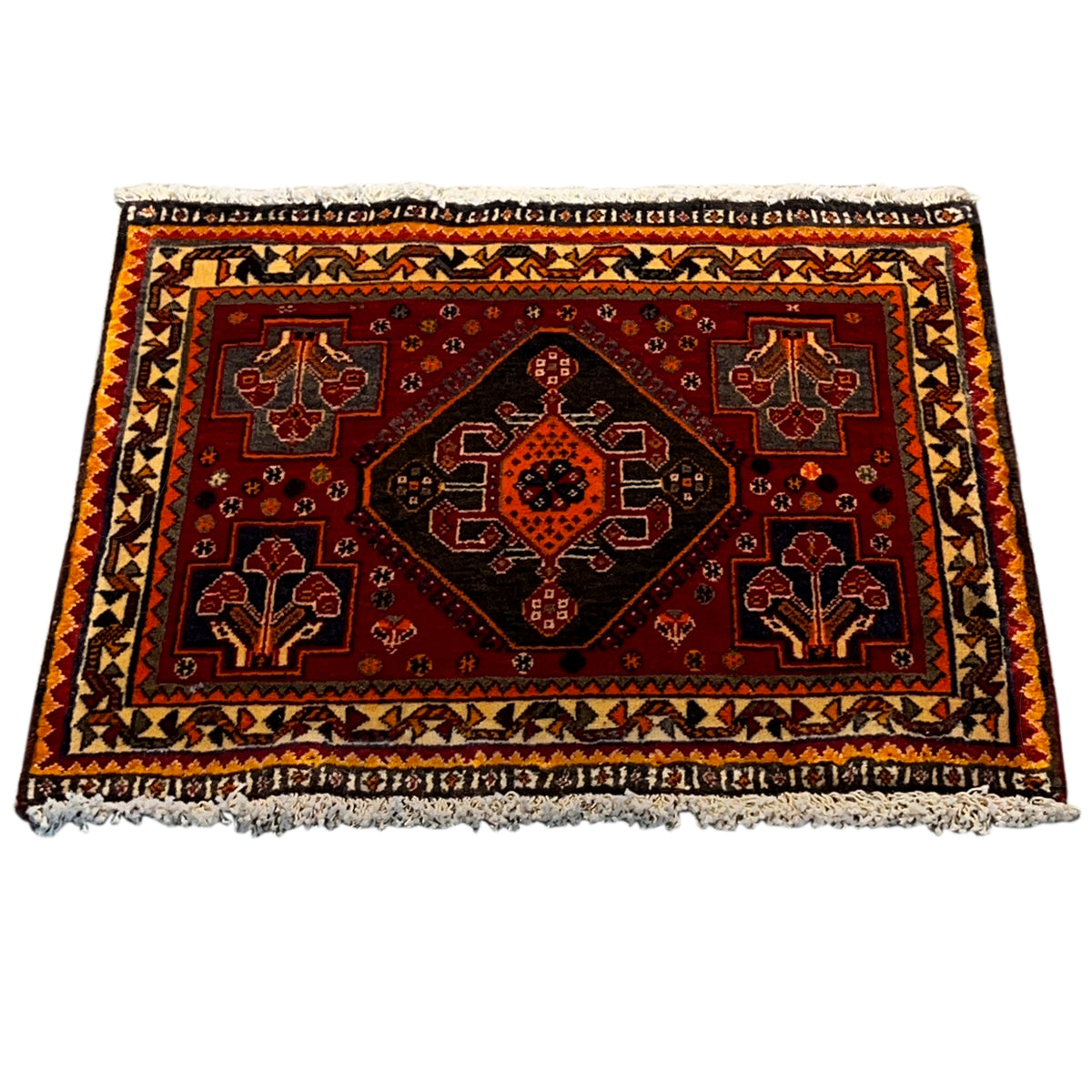 Carpet with a red background, symmetrical ornamental pattern, and beige decorative border around the edge