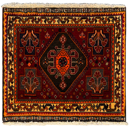Rug with a red background and geometric pattern, surrounding decorative border, and fringes