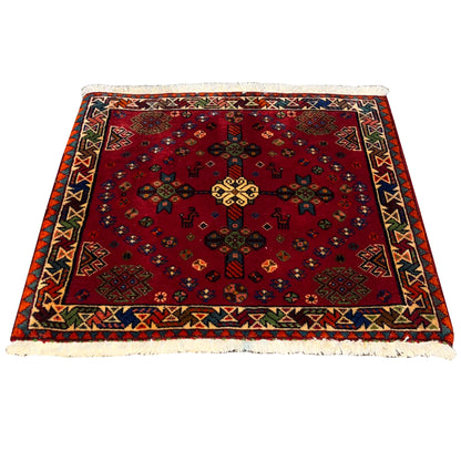Red Poshti rug with a central medallion, multicolored patterns, and fringe, 55x56 cm