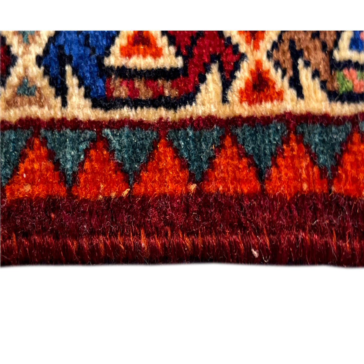 Close-up of a sample area of a red Poshti rug with multicolored sections and edge