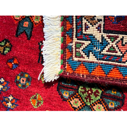 Detail at the edge: fringe and multicolored border of a red Poshti rug
