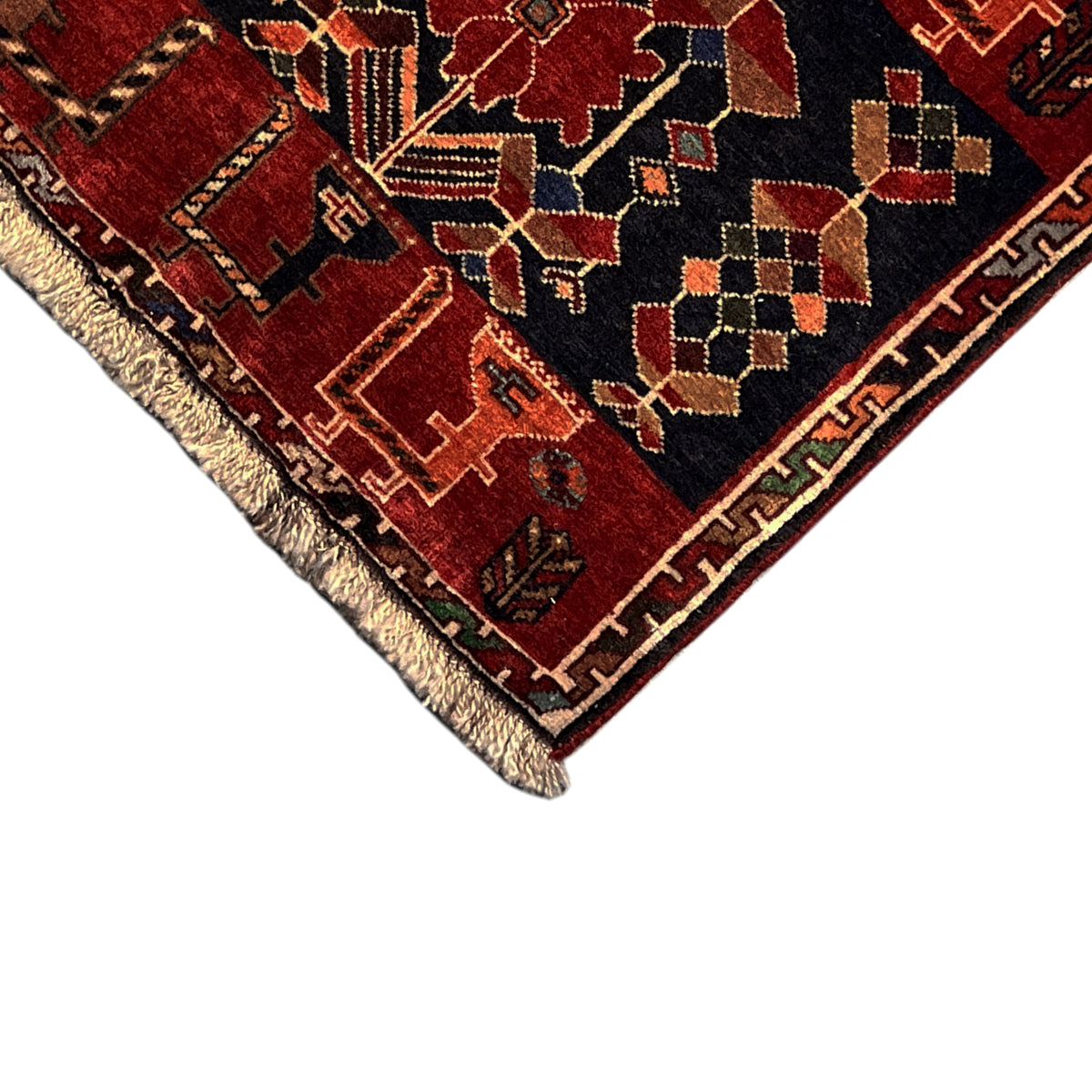 Poshti rug up close: dark blue and red ornamental pattern with fringes