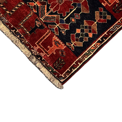Poshti rug up close: dark blue and red ornamental pattern with fringes