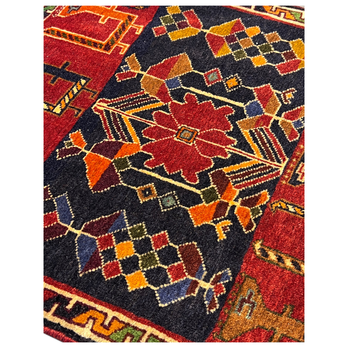Poshti rug detail view with a colorful geometric pattern in red, dark blue, and yellow