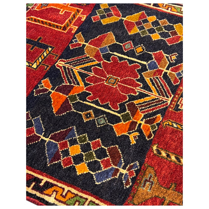 Poshti rug detail view with a colorful geometric pattern in red, dark blue, and yellow