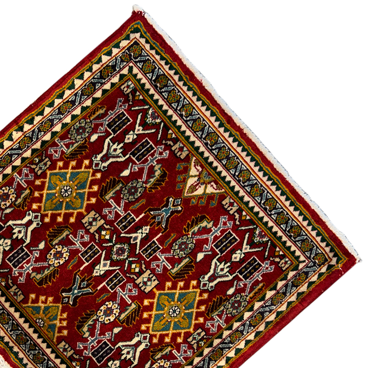 Corner of a rug with a red ornamental field, yellow-green border, and fringe
