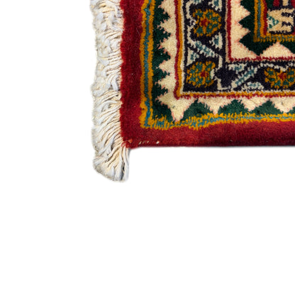 Carpet edge with white fringe along the border, red background with a pattern