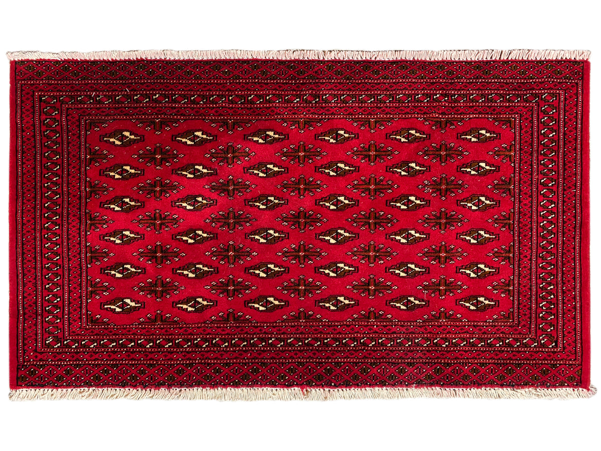 Rechteckiger Teppich in Rotbraun mit zentralem Ornament und dunkler Bordüre