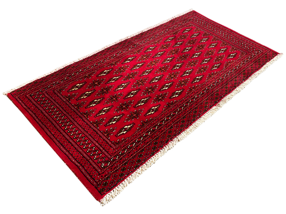 Rotbrauner Teppich mit zentralem Feld aus kleinen Motiven und eingesetzter Bordüre