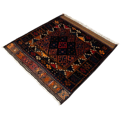Rug with a dark pattern and orange accents, border, and light-colored edge fringes
