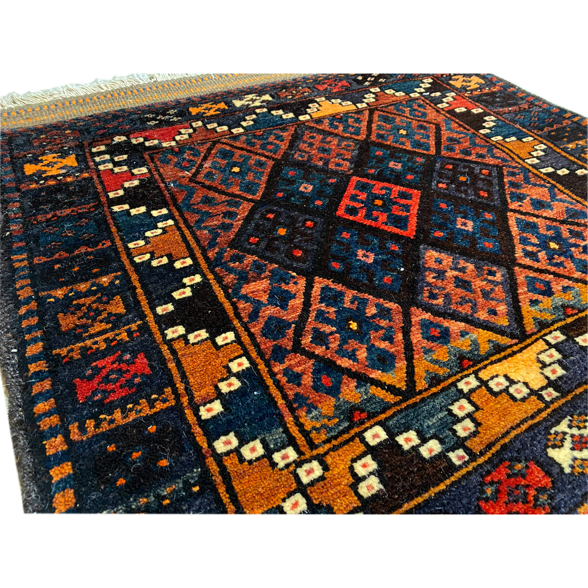 Rug detail: geometric fields and borders in blue, red, orange, and beige