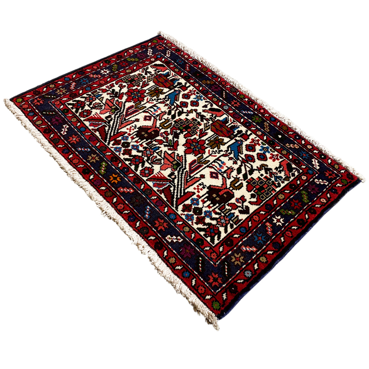Rug shown at an angle, cream-colored background with ornaments, red and blue border
