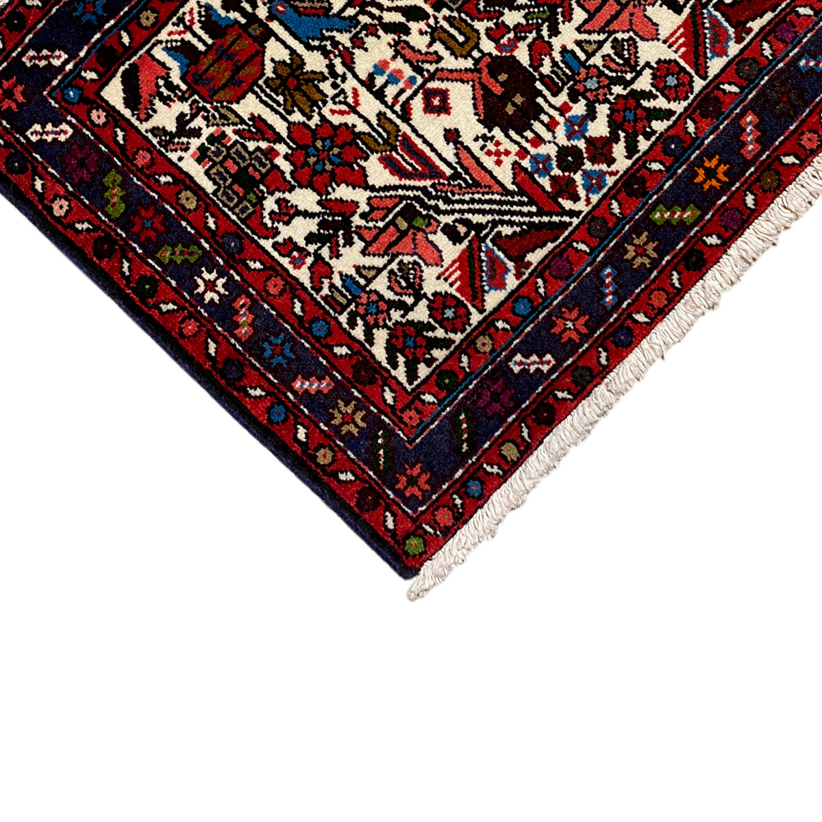 Close-up of the carpet tip: red border, cream pattern, multicolored ornaments