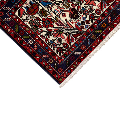 Close-up of the carpet tip: red border, cream pattern, multicolored ornaments