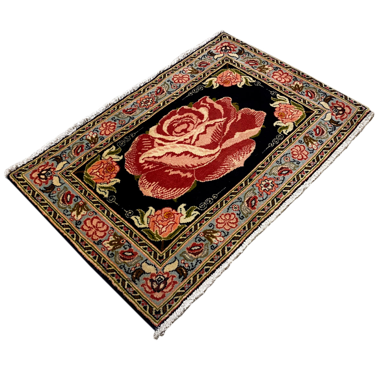 Hamedan Poshti rug laid at an angle, black ground with red rose embroidery and an ornamental border.