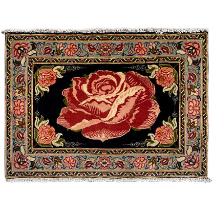 Hamedan Poshti rug with a black ground and a large red rose medallion front border.