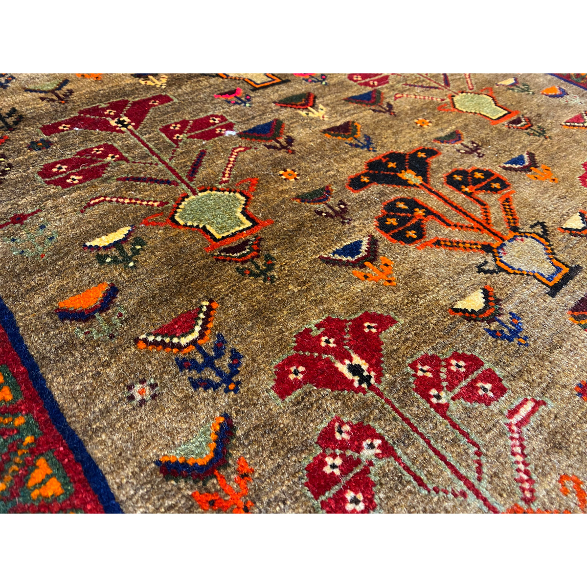 Close-up of Poshti rug 63x61 cm: beige pile with red, blue, and yellow decorative motifs