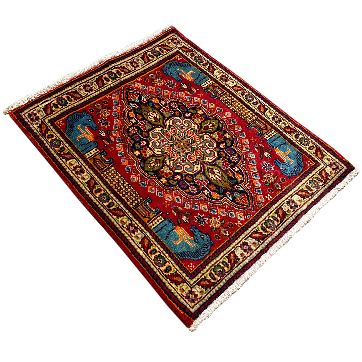 Rug in diagonal view: red field, blue corner decoration, central ornament, and animal motifs