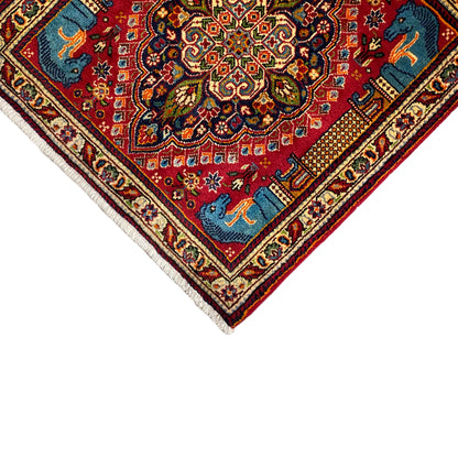 Carpet detail from above: central ornament, blue animals, red background, cream-colored border