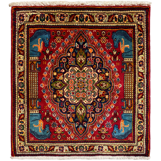 Rug with a red background, blue medallion, ornaments and animal motifs; cream-colored border