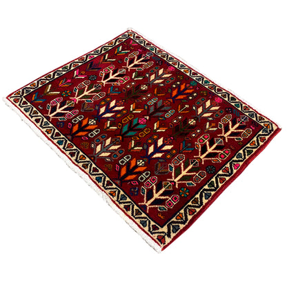 Carpet corner in view: red patterned area with stylized trees and colorful accents.