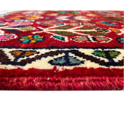 Carpet pile and border: short red pile with colorful patterned elements and a finished edge.