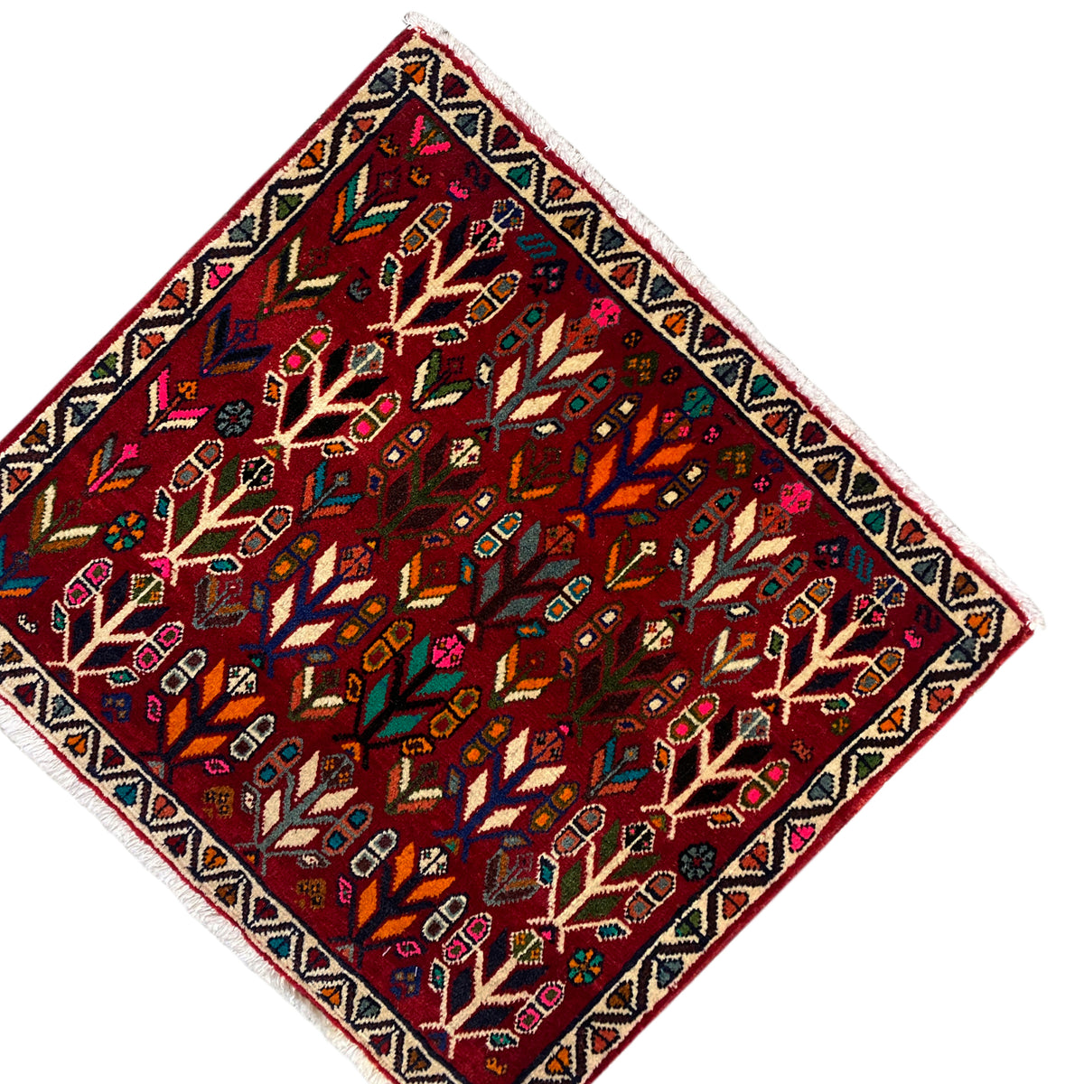 Rug at an angle: red field with rows of trees, framed border, and fine fringes.