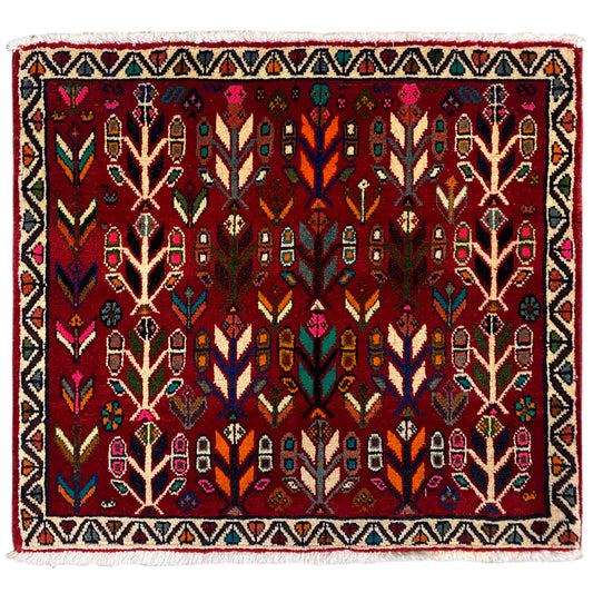 Poshti rug with a red background, multicolored tree and pattern design, fringed edge.