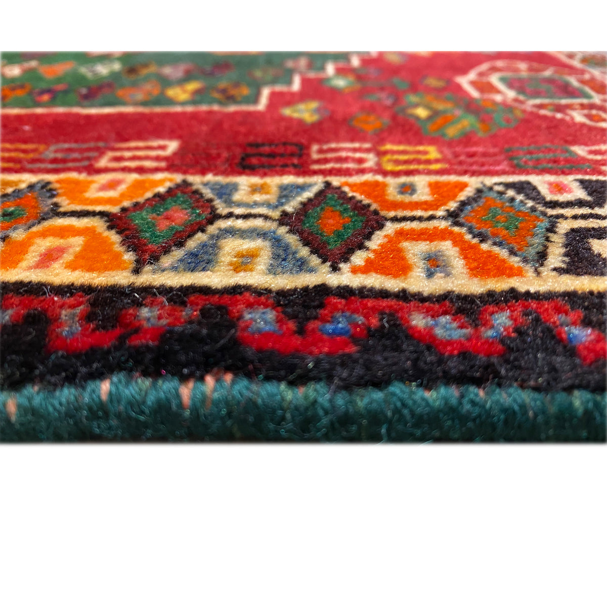 Close-up of a carpet edge: multicolored patterns with a dense, fluffy pile edge