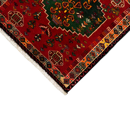 Close-up detail of the carpet: red patterned area with decorative border and white fringes