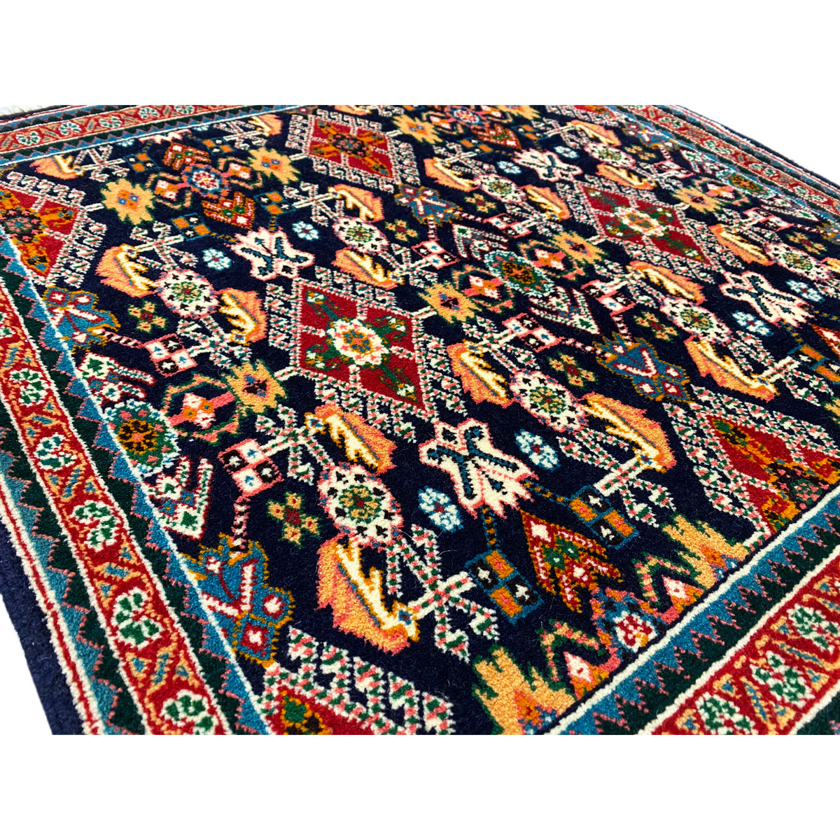 Carpet 61x60 cm close-up: dark pile with colorful floral and geometric patterns.